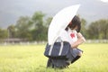 Japanese school with umbrella on rain in countryside with grass