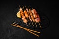 Japanese Seafood Skewers. Black tiger shrimp, scallop and salmon fillet, octopus served with lemon. Yakitori isolated on black Royalty Free Stock Photo