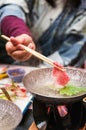 Japanese shabu hot pot with sliced beef on chopstick