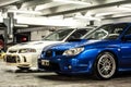 Front view of a blue Subaru Impreza WRX and white Mitsubishi Lancer Evo 4