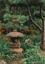 Japanese stone lantern in beautiful asian zen garden full of fresh green plants and flowers Royalty Free Stock Photo