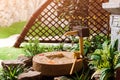 Japanese stone lantern in the garden with cho-zu fountain and maple. Traditional asian fountain in the park.