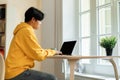 Japanese student boy studying online typing on laptop sitting indoors Royalty Free Stock Photo