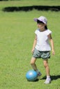 Japanese student girl playing soccer on the grass Royalty Free Stock Photo