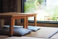 Japanese-style room decoration with wooden tables and sitting cushions floor Royalty Free Stock Photo