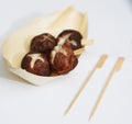 Japanese style snack in wooden cup with pick stick on white isolated background like takoyaki Royalty Free Stock Photo