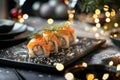 Japanese-style sushi on grey table with glamour lights, traditional cuisine ready to serve Royalty Free Stock Photo