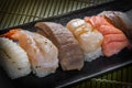 Japanese style of temaki sushi with shrimp, tuna, octopus, squid on black plate, Asian food, traditional Japanese food