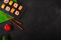 Japanese sushi chopsticks over soy sauce bowl, rice on black stone background. Top view with copy space Royalty Free Stock Photo