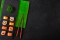 Japanese sushi chopsticks over soy sauce bowl, rice on black stone background. Top view with copy space Royalty Free Stock Photo