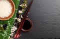 Japanese sushi chopsticks over soy sauce bowl, rice and sakura b Royalty Free Stock Photo