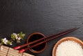 Japanese sushi chopsticks, soy sauce bowl, rice and sakura blossom Royalty Free Stock Photo