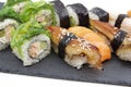 Japanese sushi food on a black tray: sushi rolls, salmon nigiri, shrimp nigiri, unagi nigiri Royalty Free Stock Photo