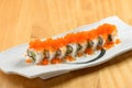 Japanese sushi food rainbow maki in a white tray isolated on wooden table top view Royalty Free Stock Photo