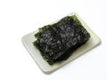 Sliced sheets of black seaweed, called Nori in Japanese and Gim in Korean language, served on a rectangular plate. Isolated on whi Royalty Free Stock Photo