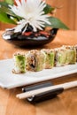 Japanese sushi roll green dragon with eel and avocado with ginger on a white plate. isolated. close up Royalty Free Stock Photo