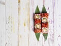 Japanese sushi roll with tempura shrimp served on bamboo leaves on wooden background Royalty Free Stock Photo