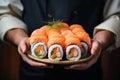 Japanese sushi with salmon in the hands of a chef close up