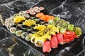 Japanese sushi set. Set of fresh tuna maki , salmon nigiri and dragon sushi rolls served on black plate close-up. Horizontal top Royalty Free Stock Photo