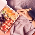 Japanese sushi set nigiri and sushi rolls served with wasabi and ginger, top view with woman`s arm