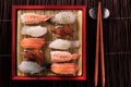 Japanese sushi various assortment red bamboo tray chopsticks above top flat view Royalty Free Stock Photo