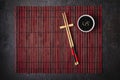 Japanese table setting. Bamboo chopsticks and soy sauce bowl on striped mat Royalty Free Stock Photo