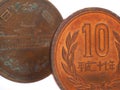 Japanese ten yen coins stand in front of a white background. Fragments close-up. Shot on a macro lens