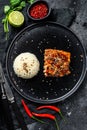 Japanese Teriyaki grilled sea trout fillet with a side dish of rice. Black background. Top view