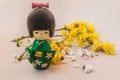 Japanese traditional doll kokesha and flower forsythia branch. Concept hanami Royalty Free Stock Photo