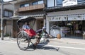 Japanese traditional hand pulled rickshaw carrying tourists on Matsubara street in Kyoto, Japan Royalty Free Stock Photo