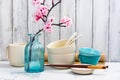 Japanese utensils, dinnerware, chopsticks and branch of blooming sakura on white asian background Royalty Free Stock Photo