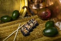 Volcano sushi roll with black rice and unagi eel served with sesame seeds with copper tableware on wooden background. Still life