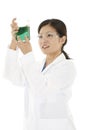 Asian laboratory technician studying a beaker of liquid Royalty Free Stock Photo