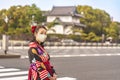 Woman in kimono in front of a dungeon of the Tokyo Imperial palace.