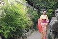 Traditional Asian Japanese woman bride Geisha wearing kimono play in a graden hold a red umbrella Royalty Free Stock Photo