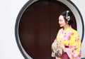 Traditional Asian Japanese woman bride Geisha wearing kimono play in a graden hold a fan Royalty Free Stock Photo