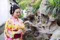 Traditional Asian Japanese beautiful woman wears kimono in a spring garden park stand by bamboo enjoy free time Royalty Free Stock Photo