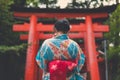 Japanese Woman in Kimono infront of a Torii tunnel