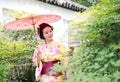 Traditional Asian Japanese beautiful Geisha woman bride wears kimono hold a red umbrella in a summer nature Royalty Free Stock Photo