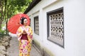 Traditional Asian Japanese beautiful Geisha bride woman wears kimono hold a umbrella in a summer nature garden Royalty Free Stock Photo