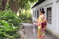 Traditional Asian Japanese beautiful bride Geisha woman wears kimono hold a white red umbrella in a summer nature garden Royalty Free Stock Photo