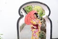 Traditional Asian Japanese woman in a garden hold a red umbrella Royalty Free Stock Photo