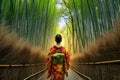 A Japanese woman in a kimono walking through a bamboo forest