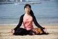 Japanese woman sitting yoga on a beach