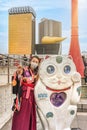 Woman wearing a mask in kimono with manekineko cat in Asakusa.