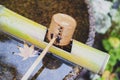 Japanese wooden purification dipper in a chozubachi or water basin used to rinse the hands in Japanese temples