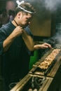 Japanese Yakitori Chef is grilling chicken marinated with ginger, garlic and soy sauce with a lot of smoke