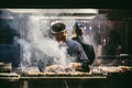 Japanese Yakitori Chef is grilling chicken marinated with ginger, garlic and soy sauce with a lot of smoke