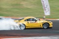 Japanese yellow Nissan 350Z car skidding on a circuit