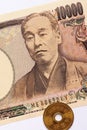 Japanese 10000 yen bill and coin lie on a white paper background. Vertical shot. Japan`s economy, central bank, national currency Royalty Free Stock Photo